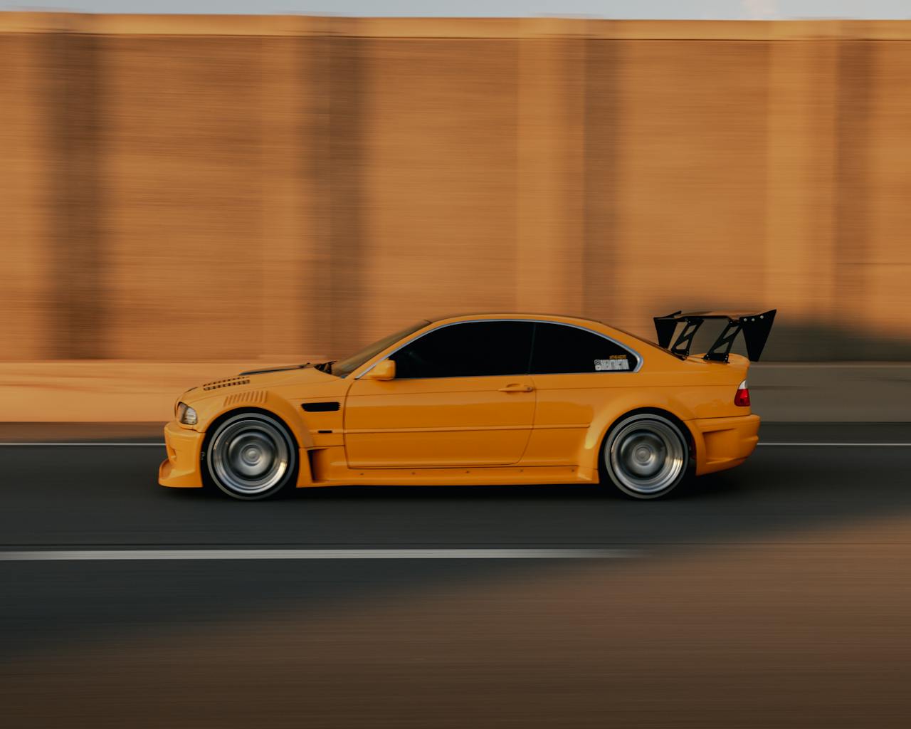 Yellow BMW E46 car speeding on an road in EST.